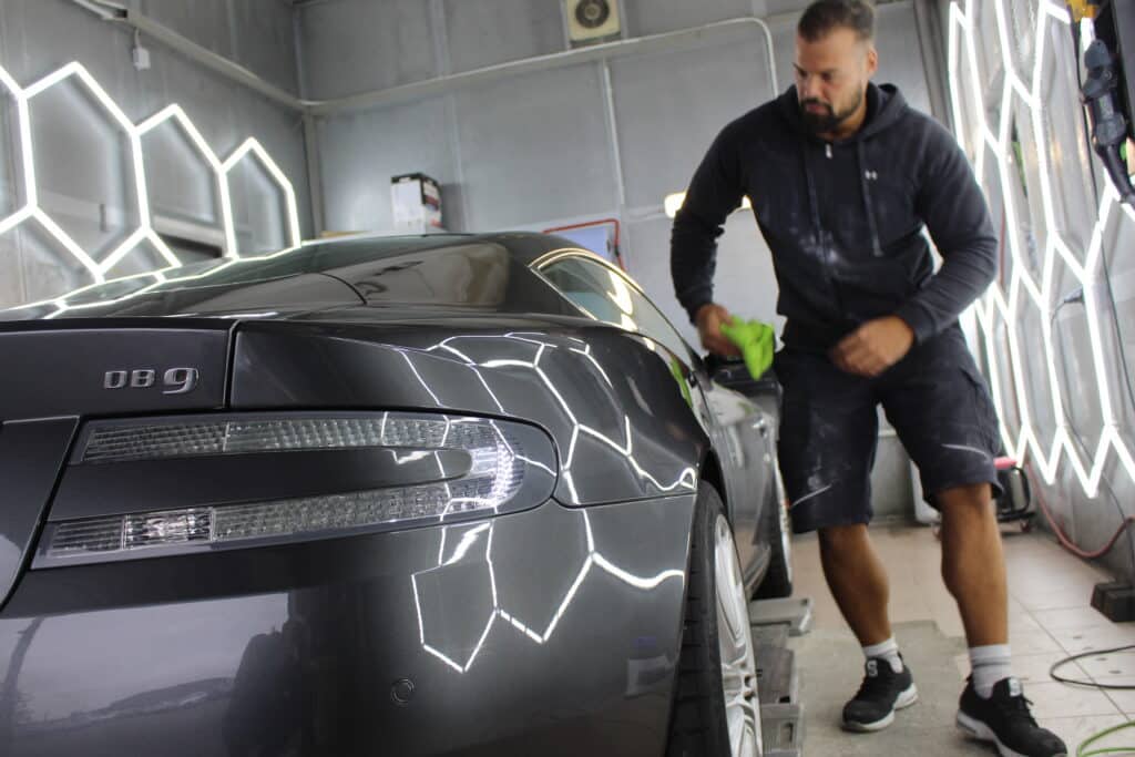 Mann poliert Auto in Werkstatt