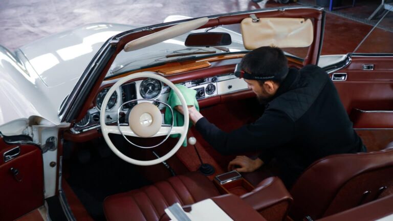 Lenkrad und Armaturen eines Oldtimers werden gereinigt